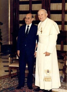 two men in suits standing next to each other