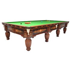 an antique pool table with green cloth on the top and gold trimming around the edges