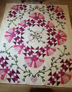 a pink and white quilt with flowers on it