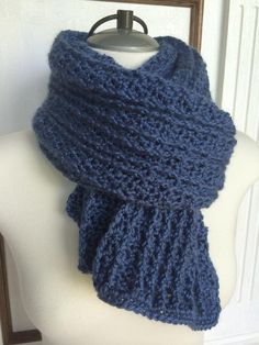 a blue knitted scarf sitting on top of a mannequin