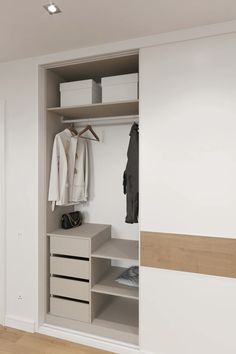 an open closet with clothes hanging on the wall and shoes in the bottom drawer next to it