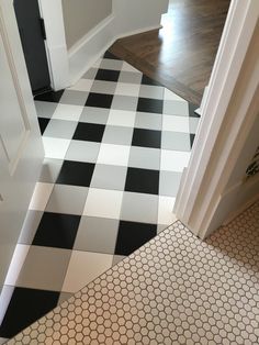 a black and white checkered floor in a house with wood floors, an open door