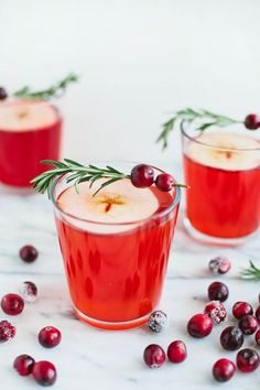 two glasses filled with cranberry punch and garnished with rosemary