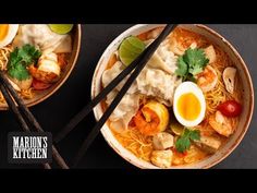 two bowls filled with noodles and shrimp next to chopsticks