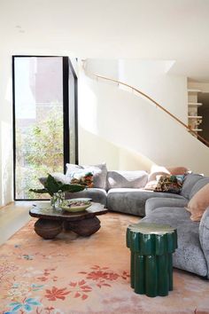 an instagram photo of a living room with furniture on the floor and stairs in the background