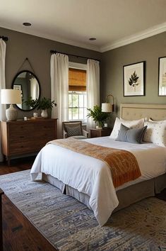 a bedroom with a bed, dresser and mirror on the wall next to two windows