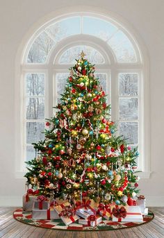 a decorated christmas tree sitting in front of a window