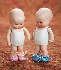 two small plastic babies standing next to each other