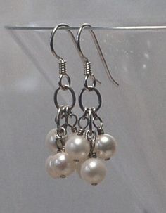 Good quality white fresh water pearl clusters are featured in these pierced earrings. All metal is 925 sterling silver. Each earring weighs 2.1 grams compared to a US dime weighing 2.268 grams. Size and length can be determined in the photo above as compared to a US dime and a ruler. For questions and or requests feel free to contact me. These earrings are ready to ship free via USPS Priority Mail with insurance. Thank You for looking. White Sterling Silver Drop Cluster Earrings, Classic Silver Dangle Cluster Earrings, Silver Dangle Cluster Earrings With Pearl Drop, White Pearl Drop Dangle Cluster Earrings, White Pearl Drop Cluster Earrings, Silver Pearl Cluster Earrings For Anniversary, Silver Cluster Earrings With Pearl Drop For Gift, Pearl Cluster, Fresh Water Pearl