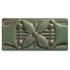 a green tile with flowers on it