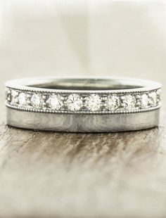 two wedding bands with diamonds on them sitting on a table