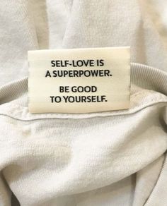 a white shirt with a tag that says self love is a super power be good to yourself