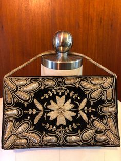 a black and gold purse sitting on top of a white table