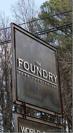 a sign for the founder of home furnishings in front of some trees and power lines