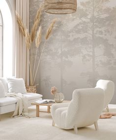 a living room with white furniture and wallpaper