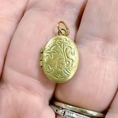 ONE tiny vintage locket in an oval shape with a floral motif. Each old stock locket has been slightly hand buffed for a warm, buttery patina. Just over a diminutive 1/2" when closed, this can possibly hold tiny photos inside. Each is unique in patina and small imperfections. COLOR: yellow brass SIZE: just over 1/2" tall and 3/8" wide when closed CONDITION: vintage old stock ONE TINY LOCKET This oval-shaped charm adorned with a delicate foor encapsulates timeless beauty and sentimental charm in its petite design. Crafted with meticulous detail, the oval-shaped locket opens to reveal a tiny compartment, offering a discreet space for treasured keepsakes or cherished photos. Its intricate floral motif adds a touch of nature's elegance, while the delicate butterfly accent brings an air of whims Vintage Gold Oval Link Locket Necklace, Vintage Gold Locket Necklace With Oval Link, Heirloom Style Oval Pendant Locket Necklace With Vintage Charm, Ornate Oval Locket Necklace From Vintage Collection, Vintage Charm Oval Locket Necklace, Victorian Oval Locket Necklace With Vintage Charm, Oval Victorian Locket Necklace With Vintage Charm, Vintage Oval Cabochon Locket Jewelry, Vintage Oval Link Jewelry With Charms