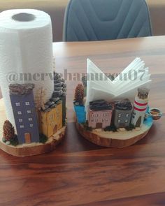 two toilet paper holders sitting on top of a wooden table