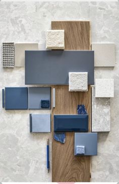 an arrangement of blue and white tiles on a wooden surface with a pen next to it