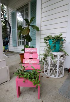 a pink bench sitting on top of a sidewalk next to a potted planter