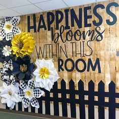 a bulletin board with flowers on it and the words happiness is blooming within this room