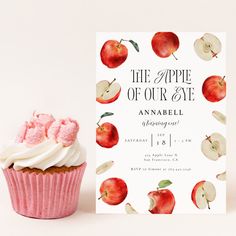 an apple cupcake next to a card with the words, the apple of our eye