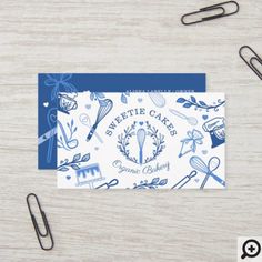 a blue and white business card sitting on top of a table next to some scissors