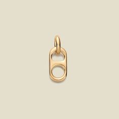 a gold plated charm with an open loop on the front and back end, hanging from