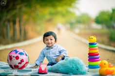 a little boy that is sitting on the ground with some toys in front of him