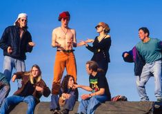 a group of people standing on top of a rock formation with one person pointing at something