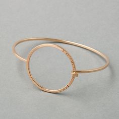 A high-polish bangle made with square wire bands, featuring a circular closure with a hammered texture one third of the way around. - Tension-connection closure- Circle measures 1 ¼” wide- 2mm thick bandSequence Collection Modern Hammered Yellow Gold Bracelets, Modern Hammered Open Circle Jewelry, Modern Hammered Bangle Bracelets, Modern Rose Gold Bangle, Modern Rose Gold Round Bangle, Modern Adjustable Hoop Cuff Bracelet, Modern 14k Gold Hoop Bracelets, Modern Hammered Round Bracelets, Modern Hammered Metal Bracelets