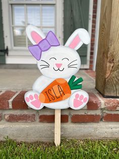 a wooden sign with a bunny holding a carrot