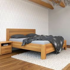 a bed sitting on top of a wooden floor next to a night stand and nightstand