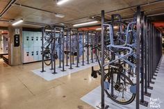 there is a bike rack in the middle of this room with many bikes on it