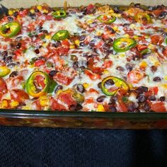 a casserole dish filled with black beans, green peppers and cheese on top