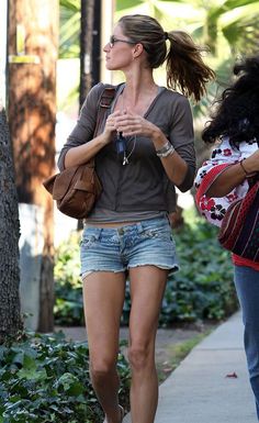 a woman walking down the sidewalk with her purse