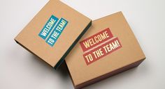 two boxes with welcome to the team stickers on them