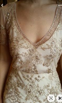 a woman wearing a white dress with gold sequins on it