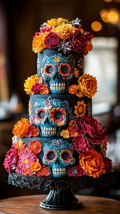 a multi - tiered cake decorated with sugar skulls and colorful flowers is displayed on a table