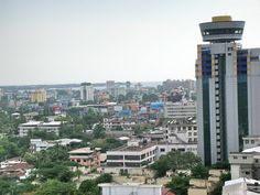 a city with tall buildings and lots of trees in the foreground is seen from above