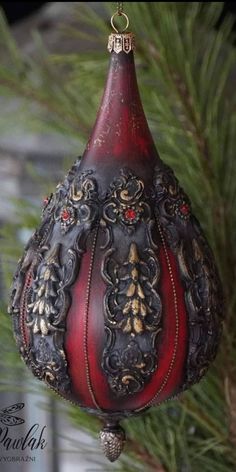 a red and black ornament hanging from a tree