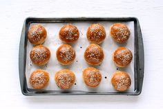 a tray filled with mini hamburgers covered in sesame seeds