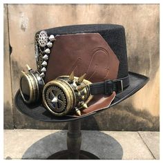 The Steampunk Hat with Goggles has a Victorian style with Steampunk elements like cogs and gears. As a bonus, the "googles" are integrated to the hat! Steampunk top hats are important for a retro-futuristic style that makes a mark, dare the Steampunk Styler style! Special use : costume or cosplay Material : polyester (durable, resistant and easy to wash and dry) Circumference: 60 cm Height : 16 cm Choose and dare to be different with the Steampunk Leather Hat. Wear a Steampunk Hat with unique st Steampunk High Crown Costume Accessories For Cosplay, Steampunk Brimmed Costume Hat For Cosplay, Vintage High Crown Costume Hats For Cosplay, Steampunk High Crown Costume Hat, Steampunk Mini Hat With High Crown, Steampunk Mini Hats For Festivals, Steampunk Brimmed Mini Hats For Cosplay, Black Steampunk Costume Hats And Headpieces, Steampunk High Crown Top Hat For Cosplay