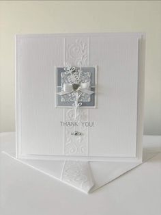 a white card with a cross on it and the words thank you written in silver