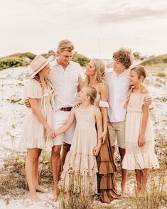 a group of people standing next to each other on a beach