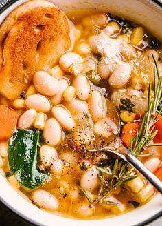 a white bowl filled with beans, carrots and bread