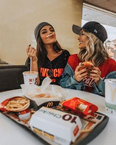 two women sitting at a table eating food