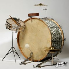 an old drum sits next to other musical instruments