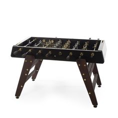 a black and gold foosball table sitting on top of a wooden stand with two legs