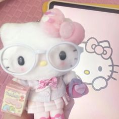 a hello kitty doll wearing glasses and holding a book