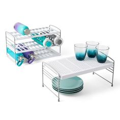 a set of dishes, cups and trays on a white table with metal rack